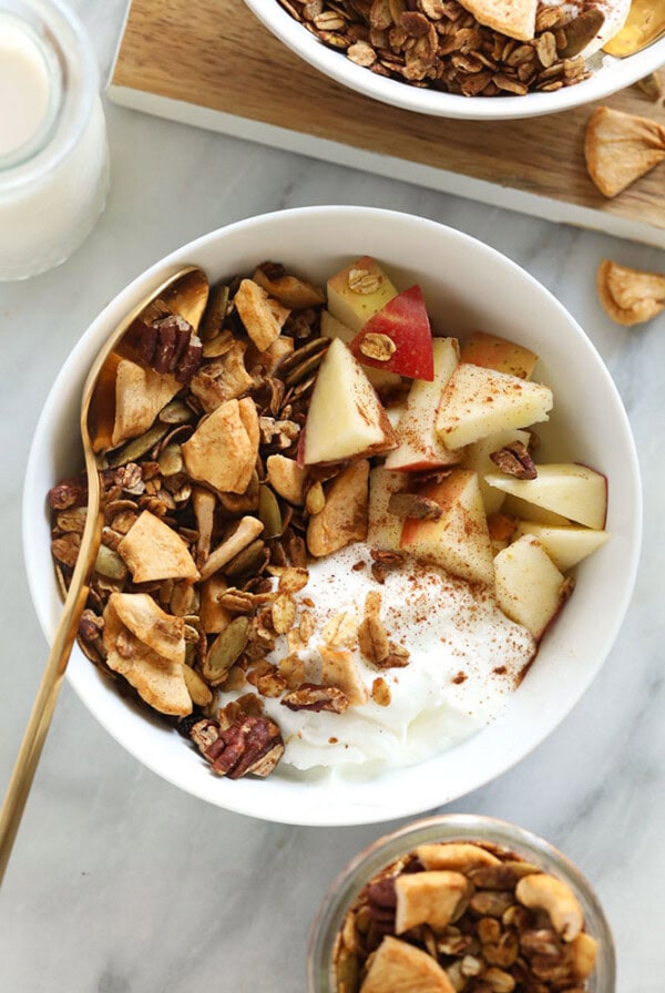 A yogurt parfait with granola and apples.