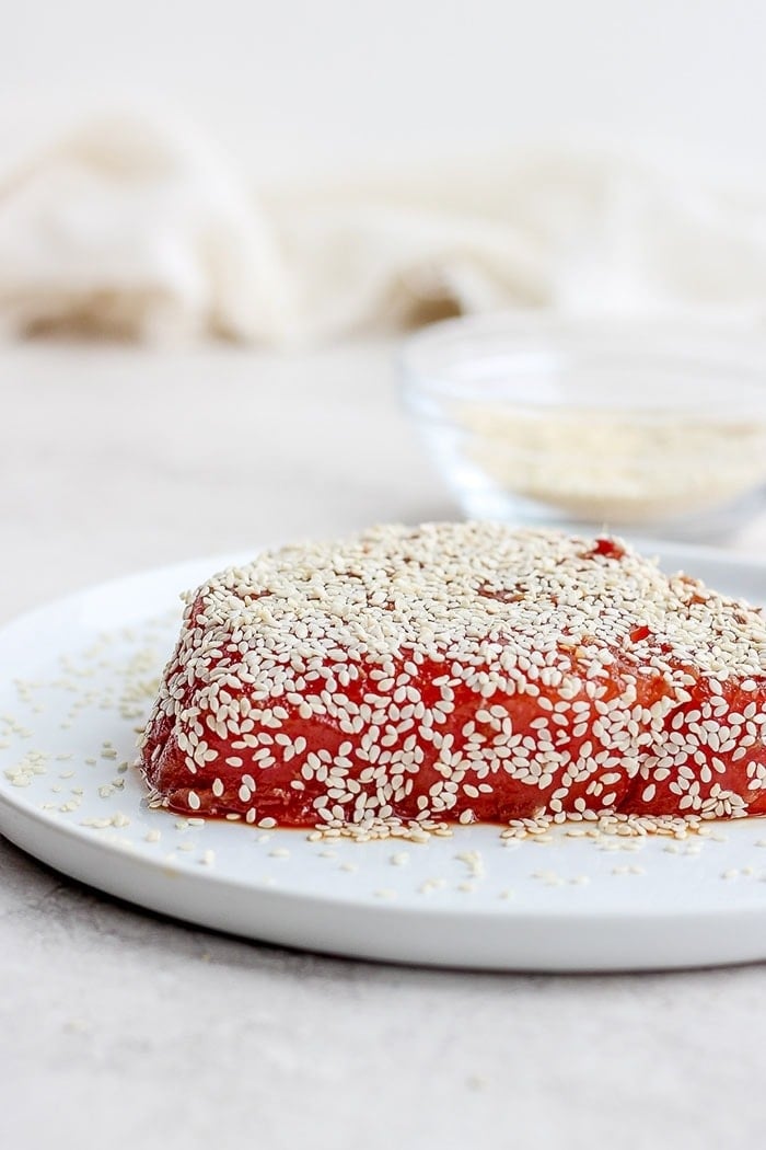 ahi tuna covered in sesame seeds on a plate.