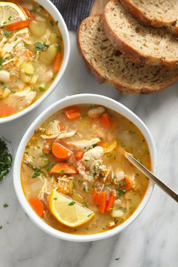 two bowls of chicken soup on a marble table.