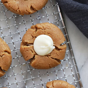 No-bake thumbprint peanut butter cookies with cream on a cooling rack.