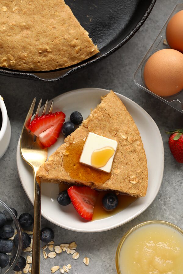 a skillet pancake with berries and syrup.