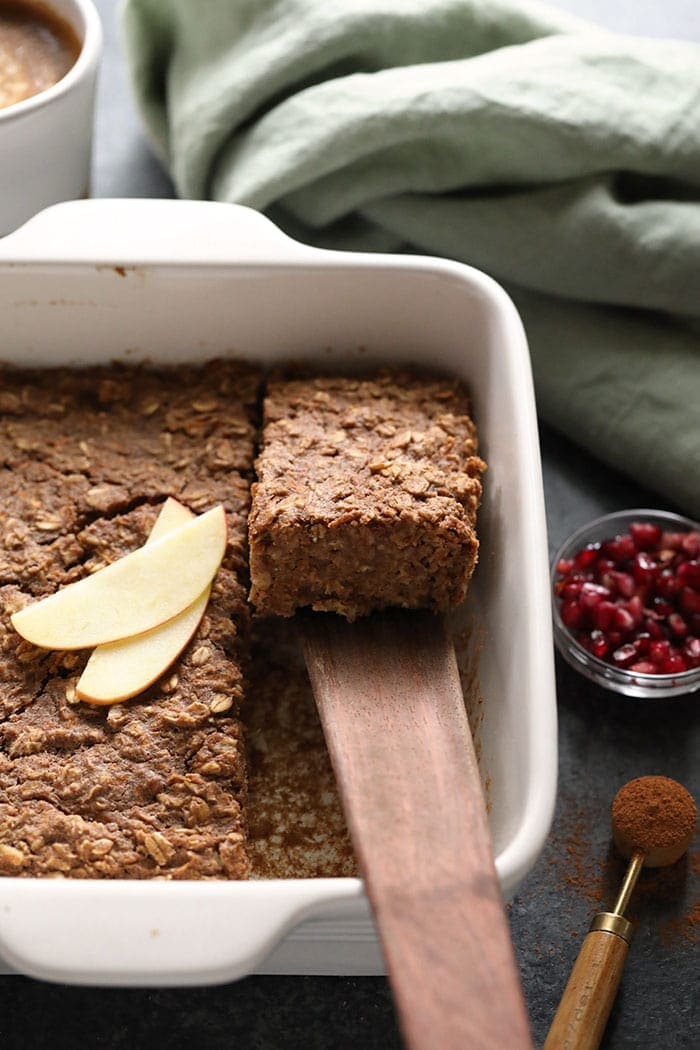 Scooping apple cinnamon oatmeal bake out of the pan.