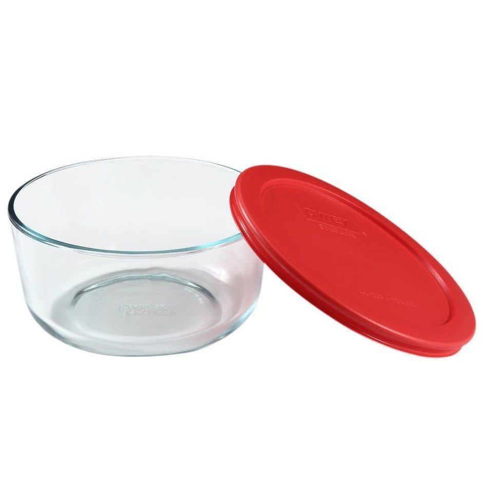 A glass bowl with a red lid for storing chai spices.