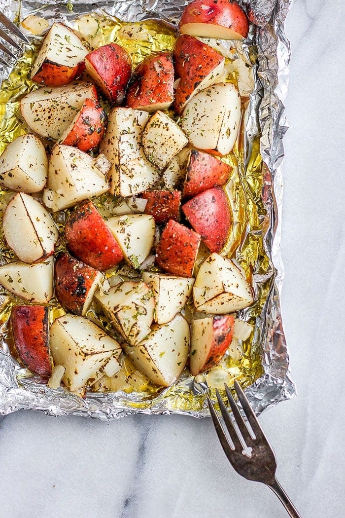 red potatoes on tin foil covered in olive oil and spices