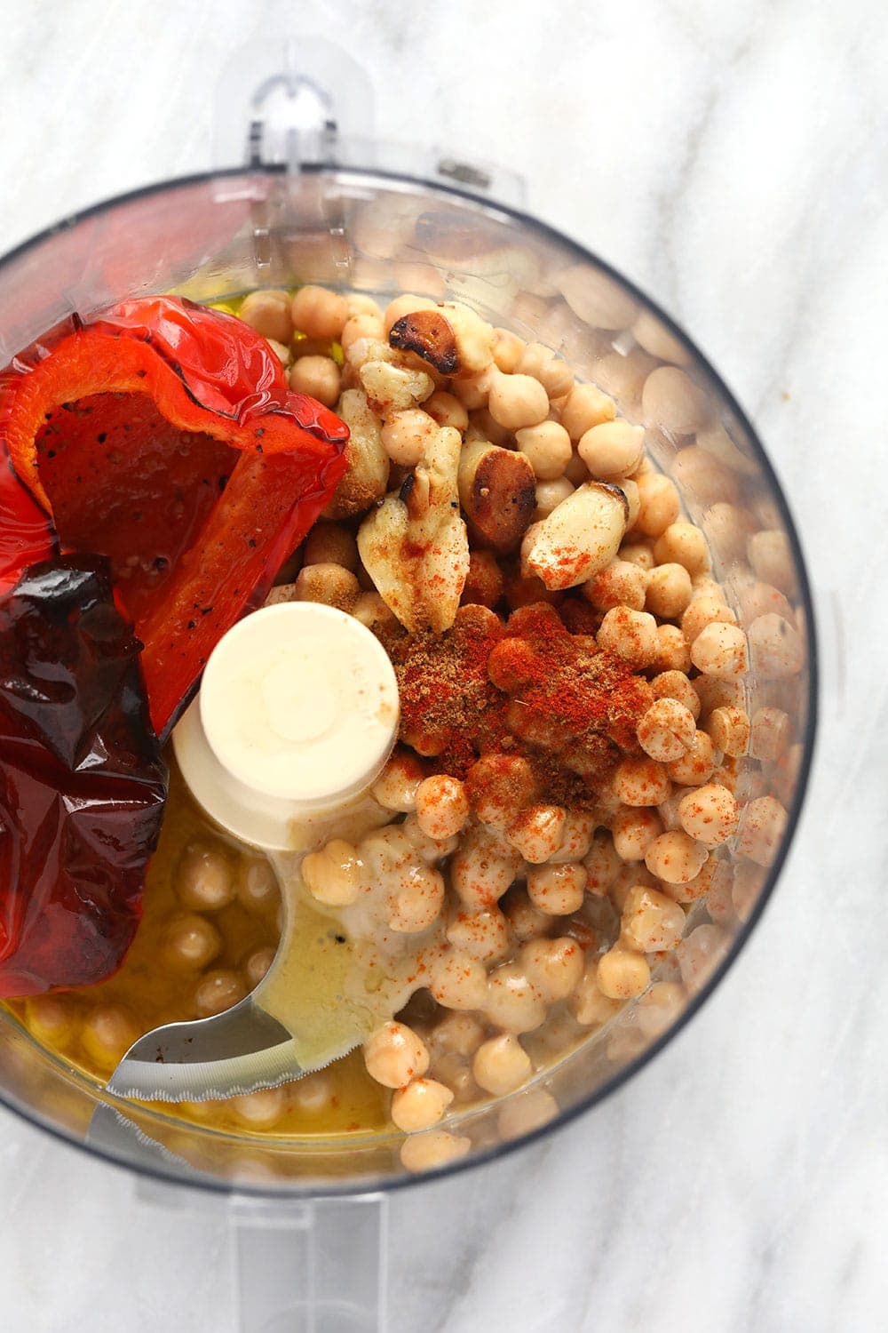 roasted red pepper hummus ingredients in a food processor ready to be blended