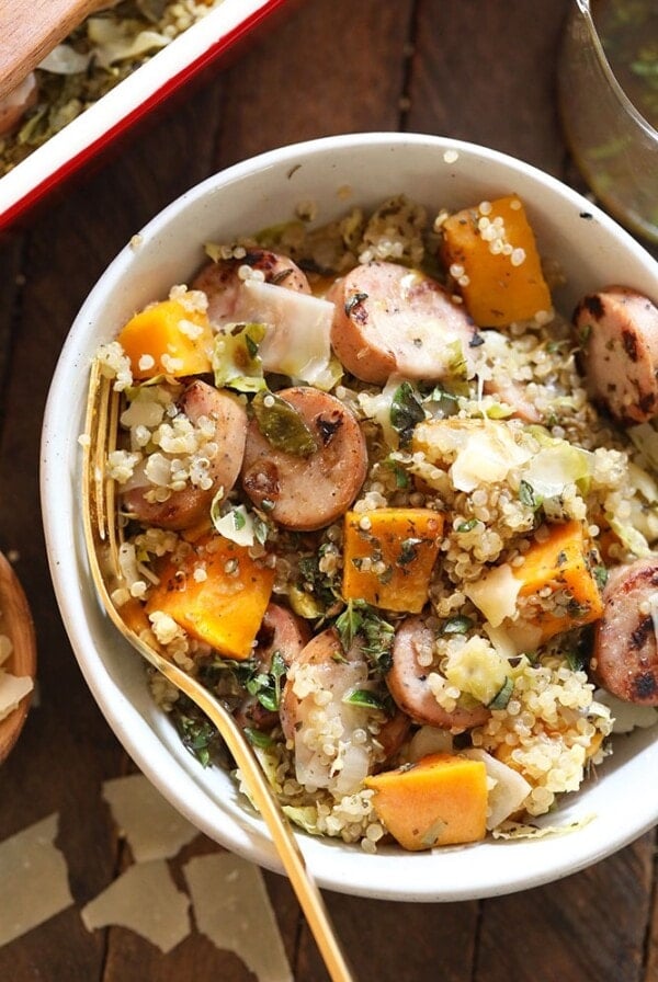 a quinoa casserole with sausage and squash in a white bowl.