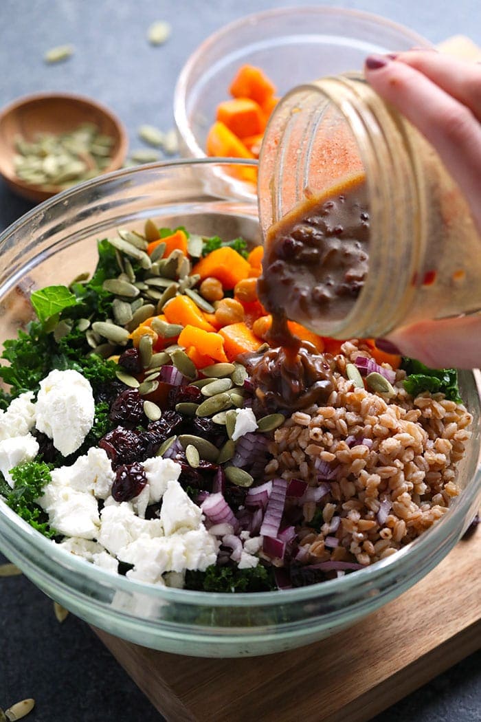 Pouring dressing over the farro salad. 