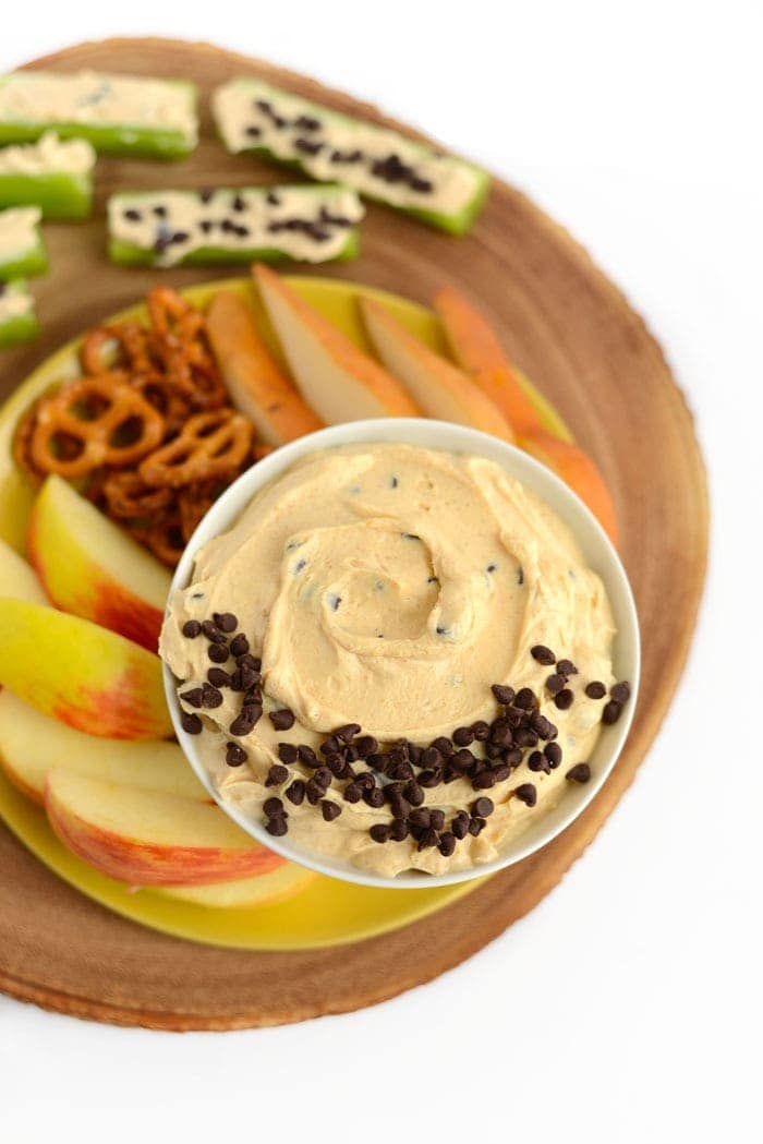 peanut butter greek yogurt dip with fruit and pretzels ready for dipping