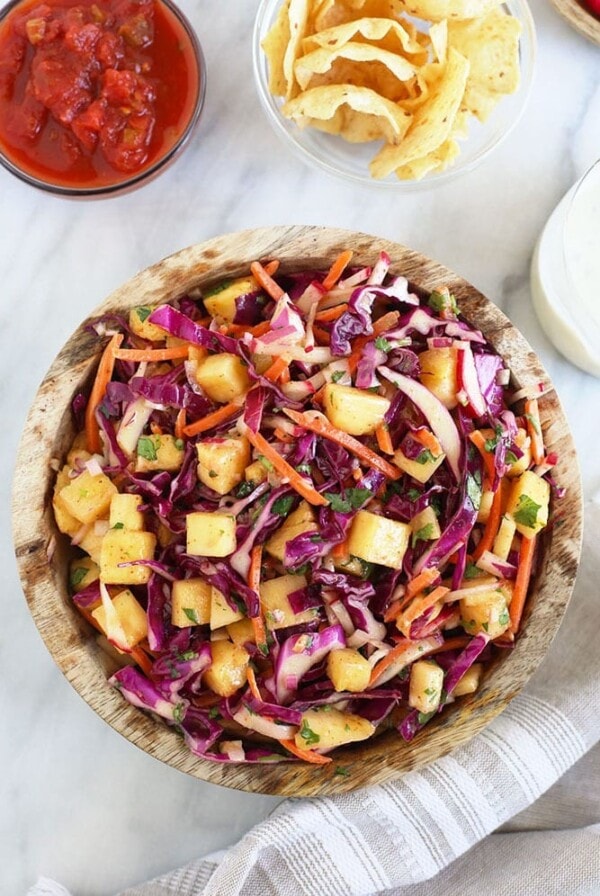 a pineapple coleslaw with chips and salsa.