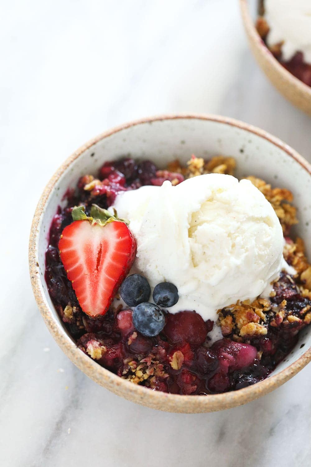 bowl of berry crisp with vanilla ice cream