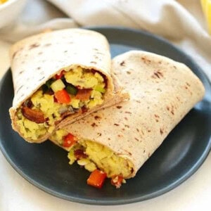 A breakfast burrito on a plate.