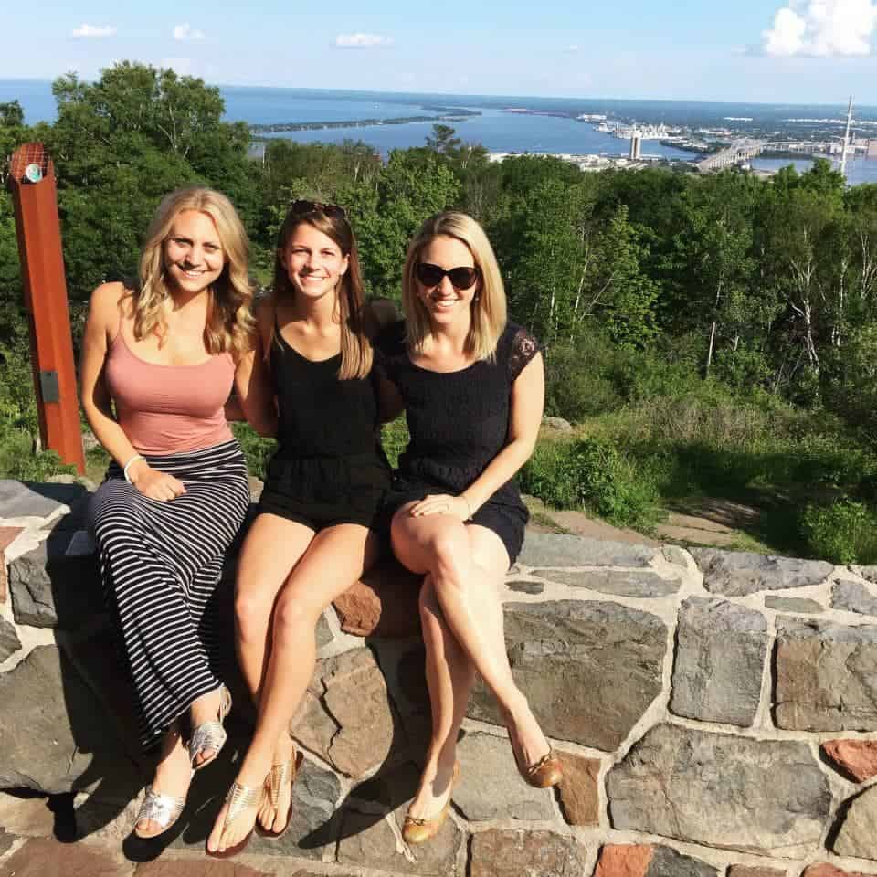 3 women sitting on rock wall