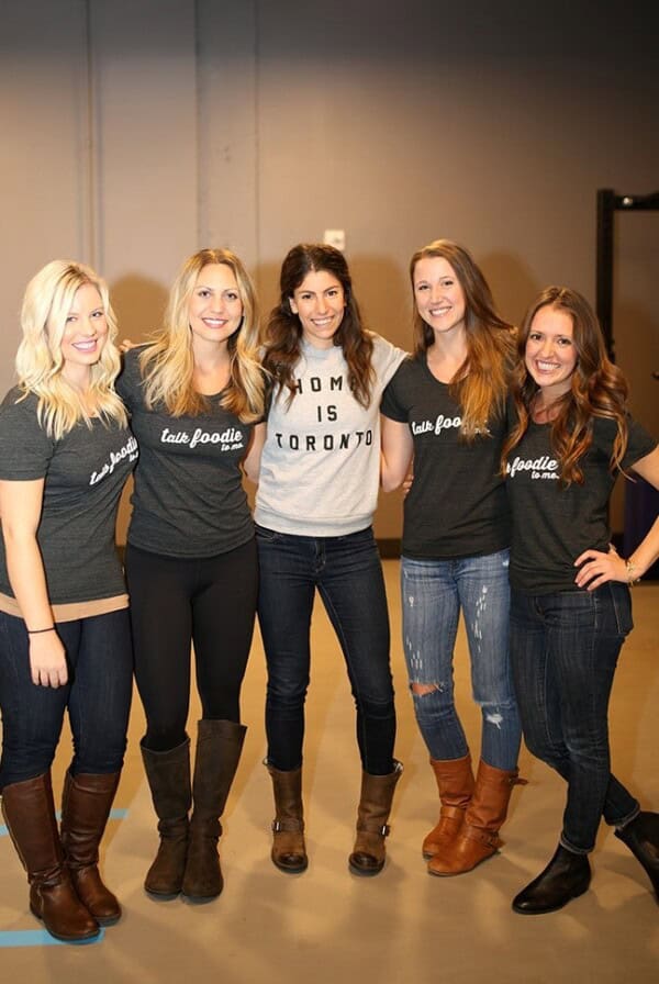 a group of women posing for a photo in a gym.