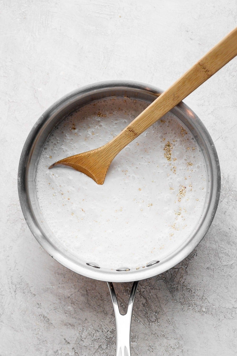 Stirring together coconut milk and quinoa