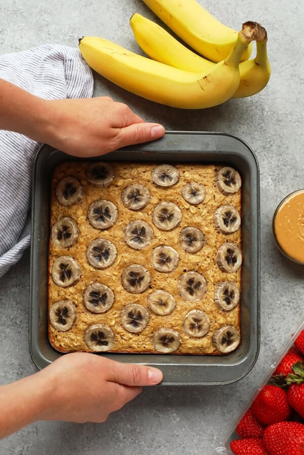 A baked oatmeal dish with banana and peanut butter, topped with strawberries.