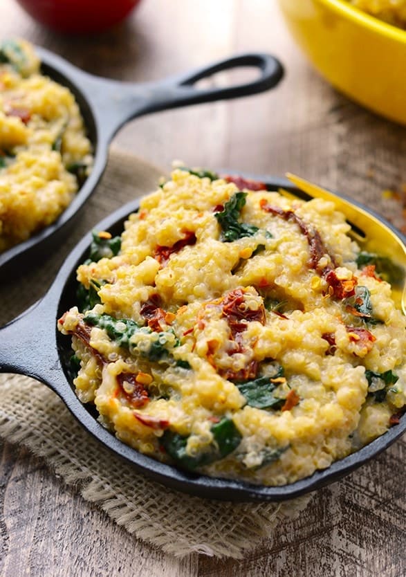 Two skillets filled with mashed potatoes, spinach and quinoa mac n' cheese.