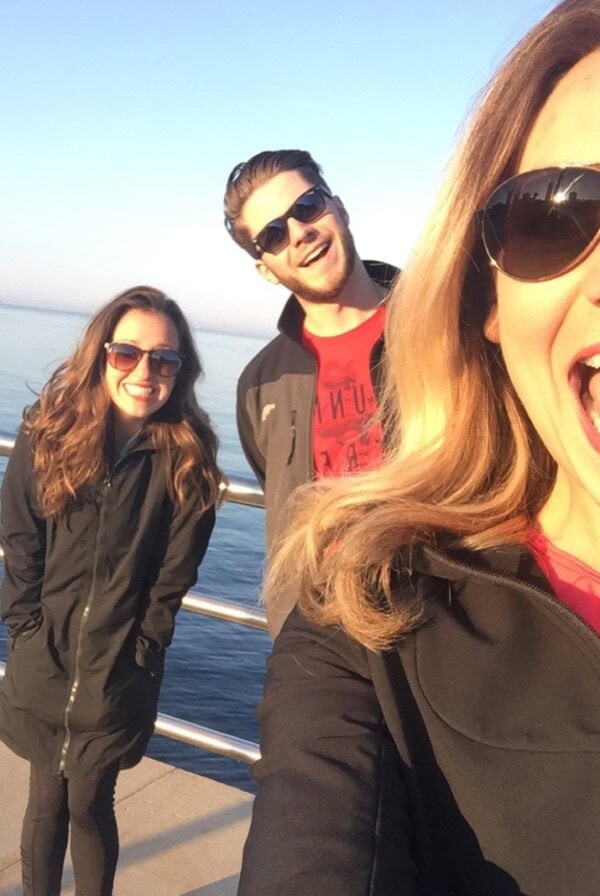 A group of people taking a selfie on a pier while performing a circuit workout.