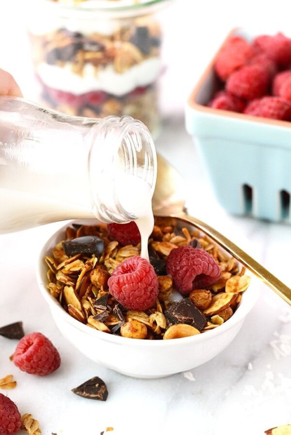 a person pouring chickpea granola into a bowl.