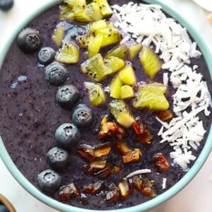 Blueberry Smoothie Bowl filled with blueberry, coconut, and kiwi smoothie.