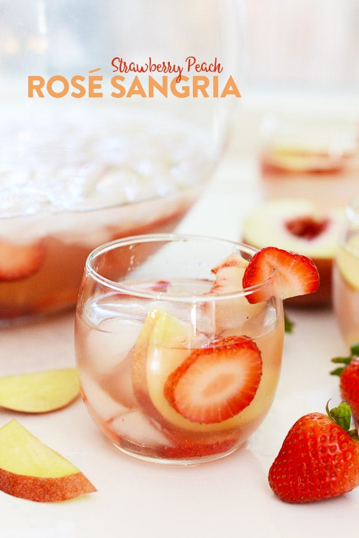 Strawberry Peach Rosé Sangria in a stemless wine glass garnished with a sliced strawberry