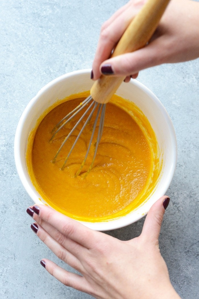 Pumpkin puree in a bowl being whisked. 