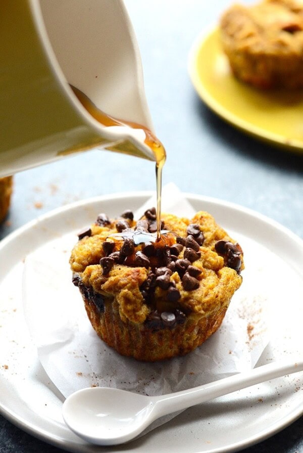 A person is pouring pumpkin liquid onto a french toast muffin cup.