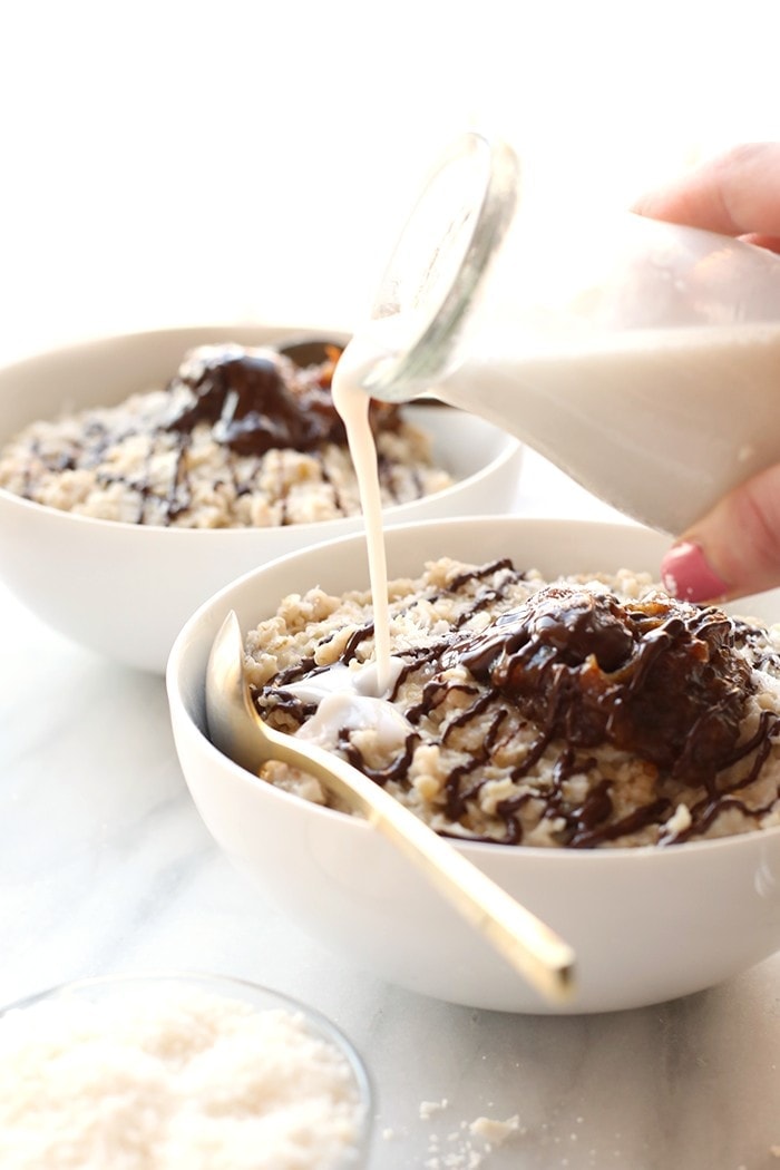 Use your slow cooker to make this decadent Crock Pot Samoa Steel Cut Oatmeal made with a coconut oatmeal base topped with homemade date caramel and a drizzle of chocolate! 