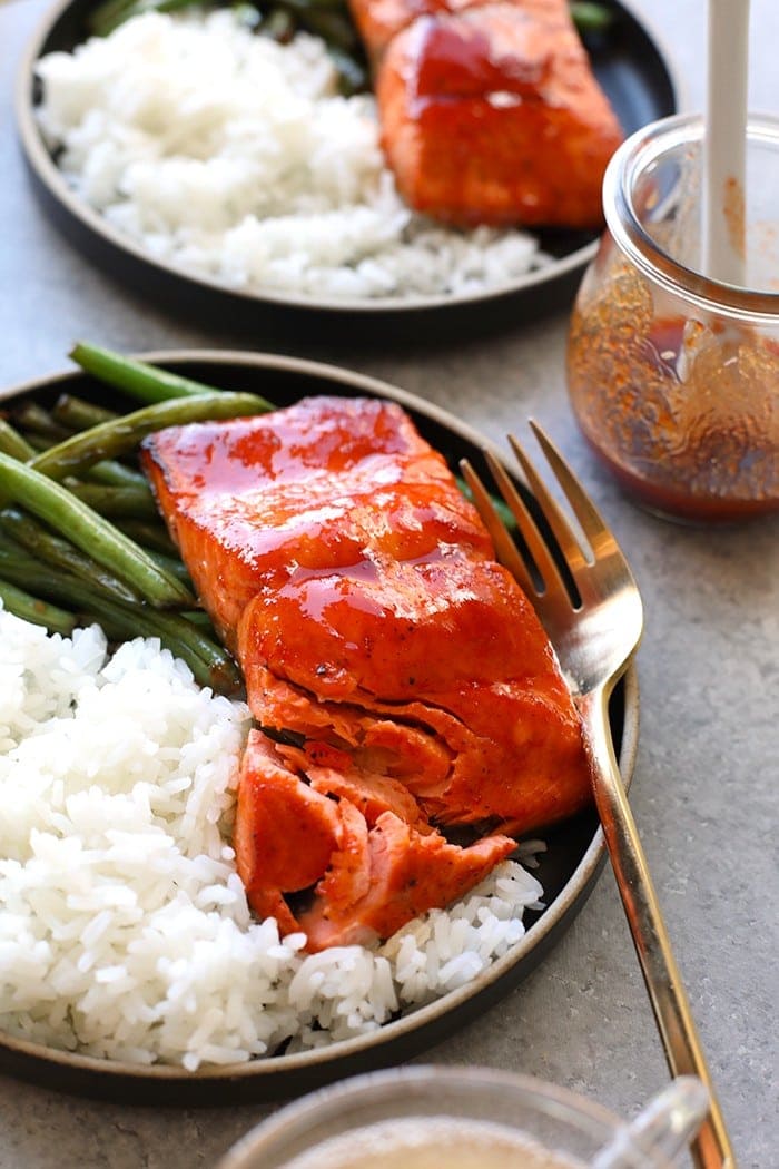 honey sriracha salmon on plate with white rice and green beans