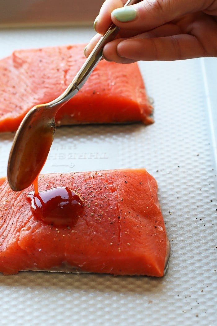 honey sriracha sauce being poured over salmon