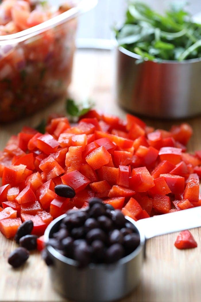 diced red peppers and measuring cup full of black beans