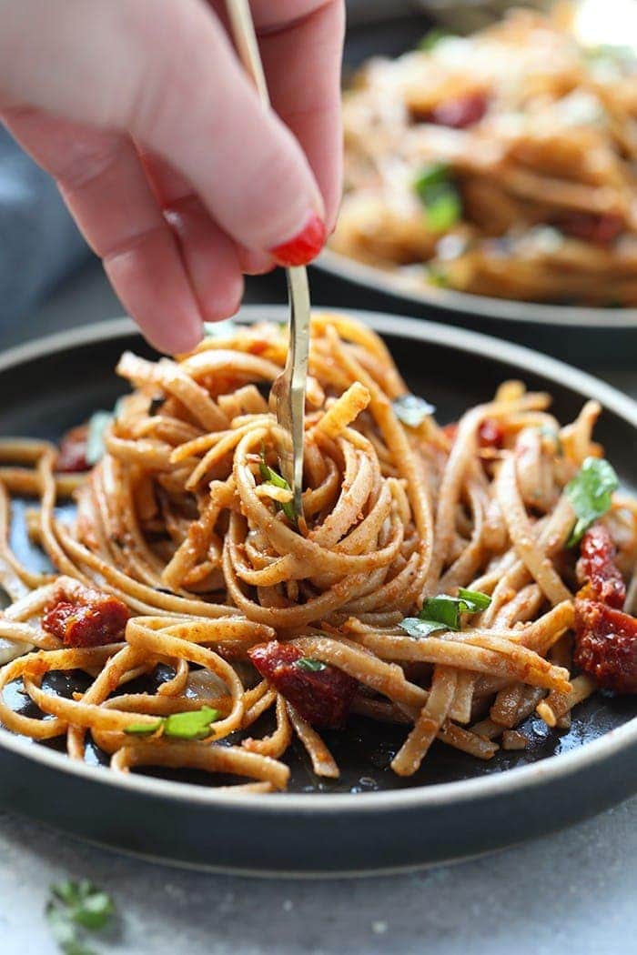 sun dried tomato pasta with whole wheat pasta twirled on fork