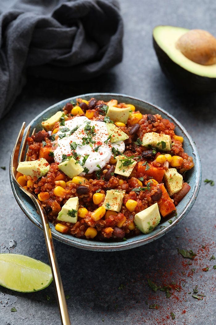 Mexican quinoa in bowl with yogurt and sliced avocado