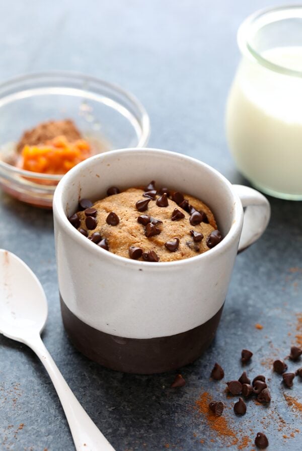 a healthy pumpkin mug cake with a spoon next to it.