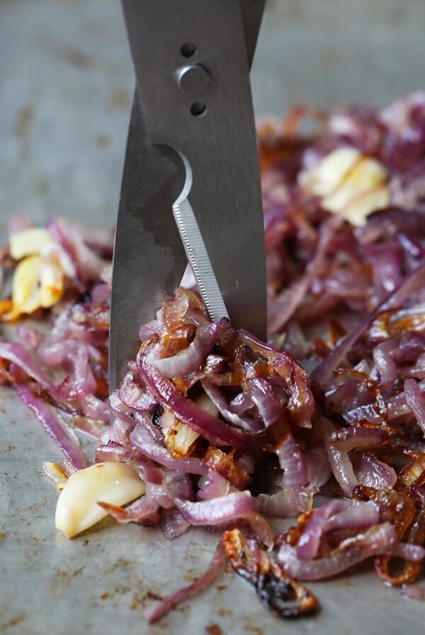 A person demonstrating how to caramelize onions in the oven.