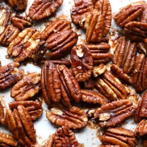 Roasted pecans arranged on a baking sheet.