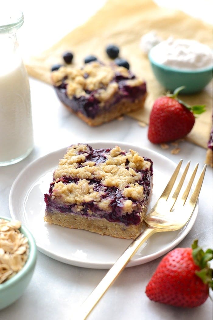 triple berry crumble bar on a plate with a fork