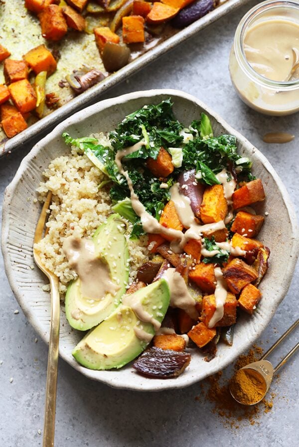 A buddha bowl featuring a sweet potato, kale, and avocado salad.