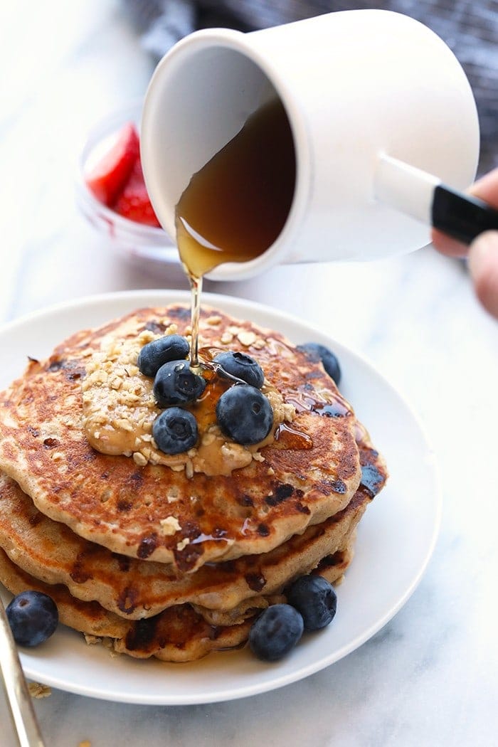 maple syrup pouring onto pancakes.