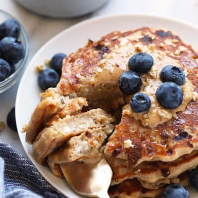 Protein-packed oatmeal pancakes with blueberries on a plate.