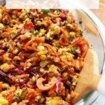 Summer corn salad in a bowl with a wooden spoon.