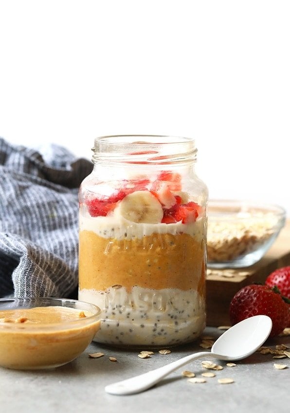 Overnight oats with strawberries and peanut butter served in a jar, paired with a refreshing watermelon salad.