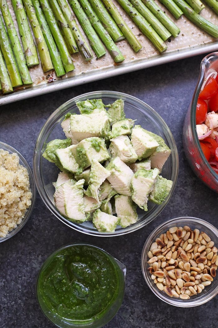 Pesto chicken in a bowl ready to be combined with asparagus