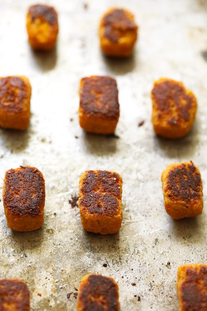 Baked sweet potato tater tots on a baking sheet.