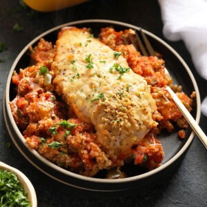 a healthy chicken dish with quinoa, tomatoes and parsley.