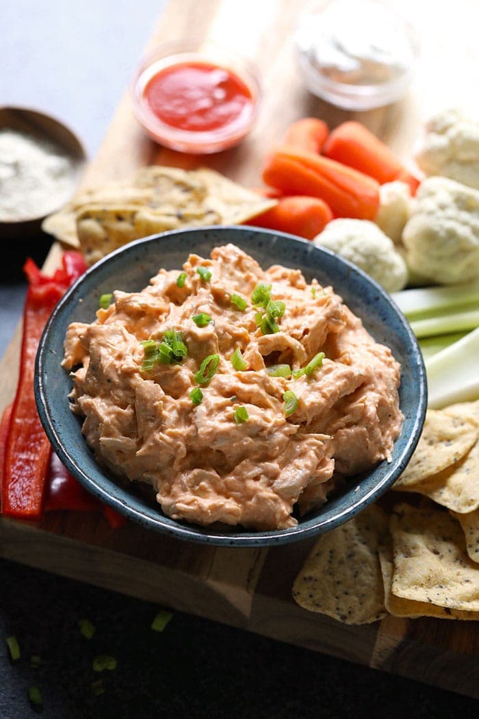 buffalo chicken dip and fixings on a cutting board. 