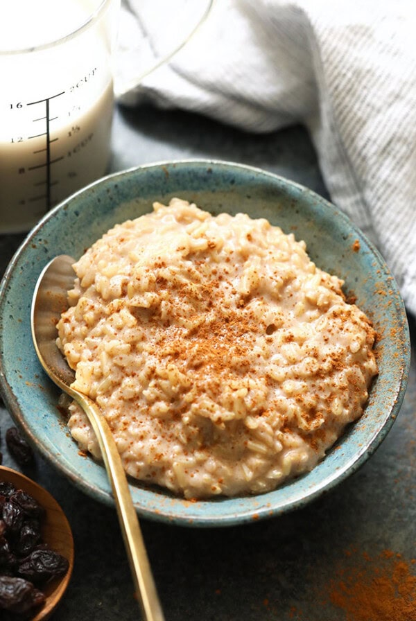 Healthy oatmeal in a blue bowl with raisins and cinnamon.