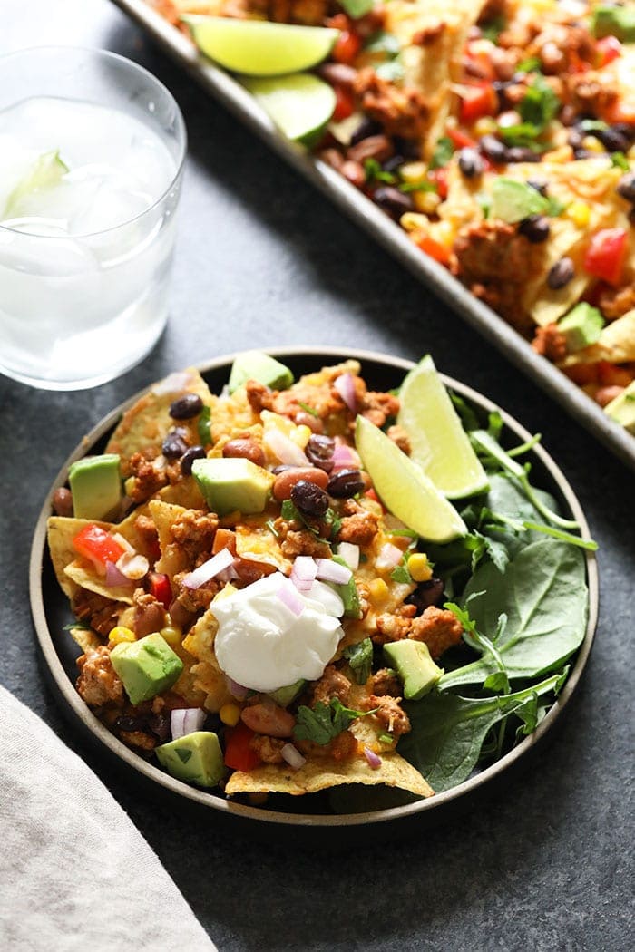 Chicken nachos on plate with sour cream. 