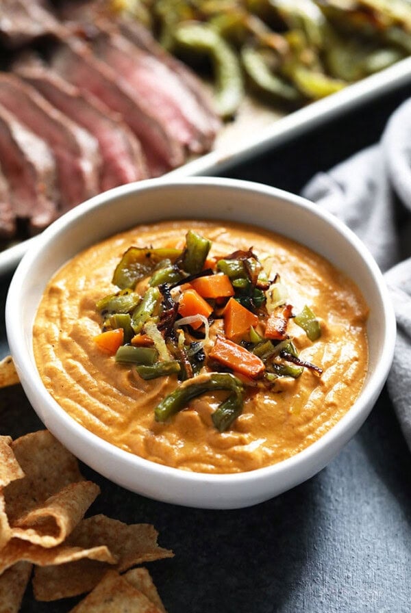 A bowl of vegan queso dip with tortilla chips.