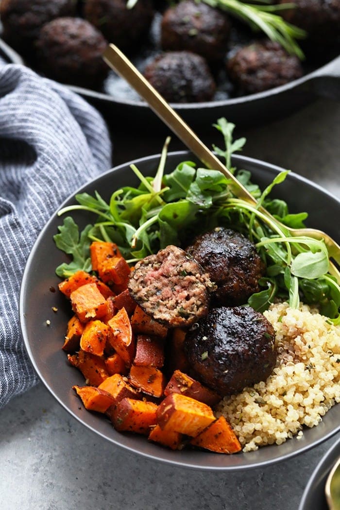 Rosemary Thyme Balsamic Meatballs in a bowl with quinoa, sweet potatoes, and arugula