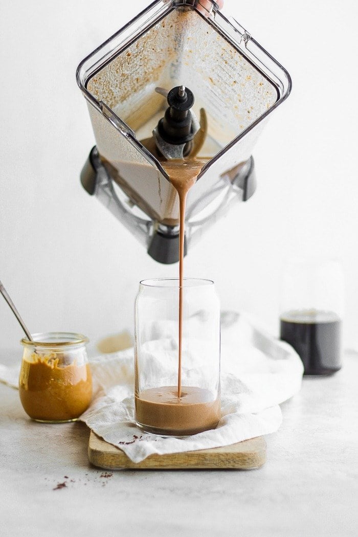 A protein smoothie being poured into a glass